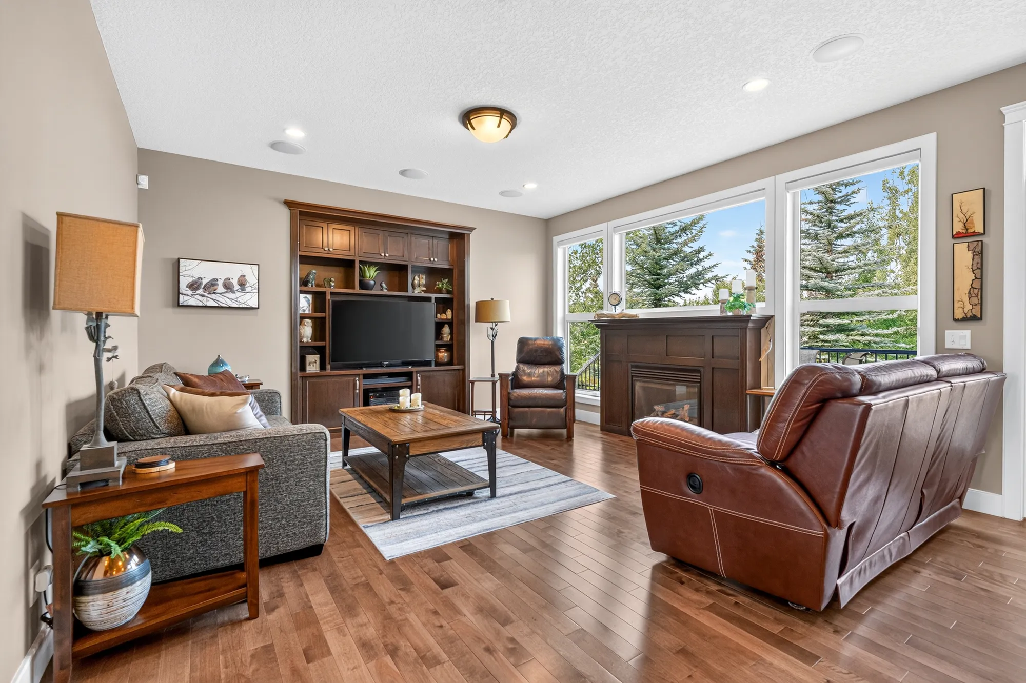 The great room at 8 Monterra Cove, anchored by a gas fireplace with a custom wood surround and flanked by built-ins.